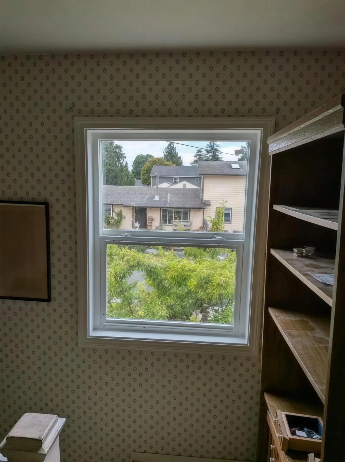 White double-hung window looking out over neighboring Washington rooftops